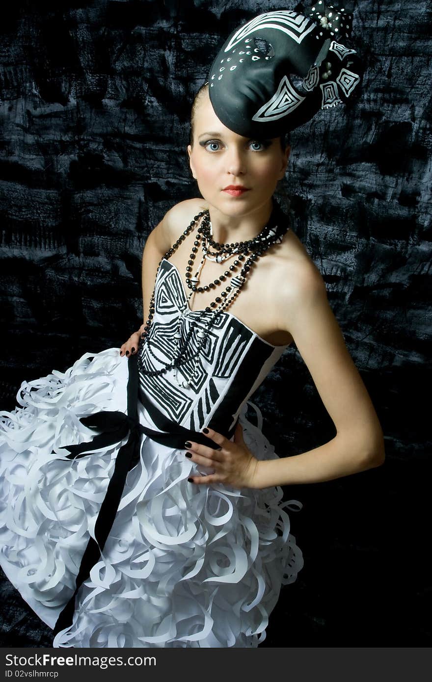 Beautiful seductive woman wearing couture and posing in a studio