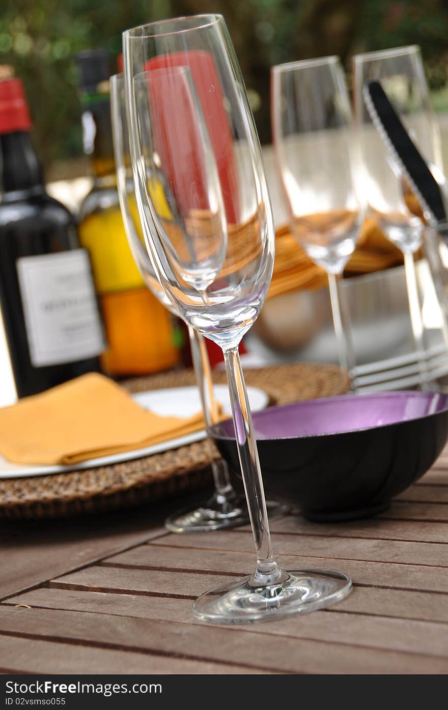 Glass of wine and wine bottle fading on background on garden table. Glass of wine and wine bottle fading on background on garden table