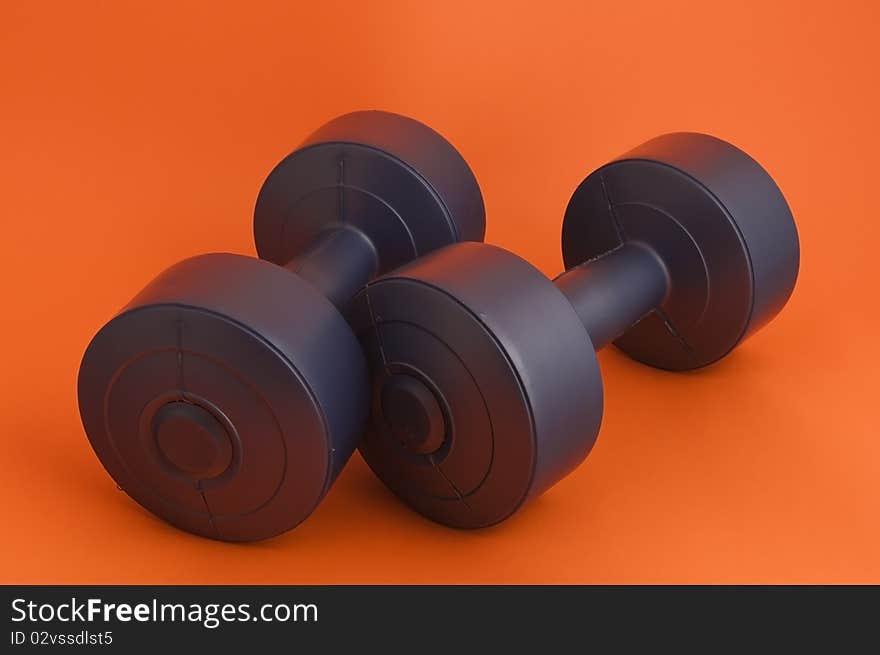 Dark blue dumbbells on an orange background