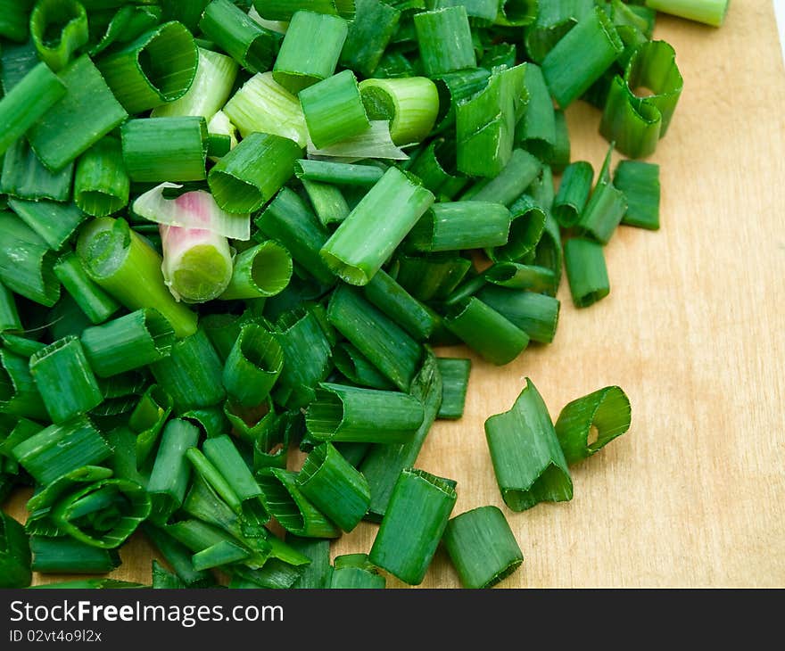 The green leek is cut by slices of the average sizes. The green leek is cut by slices of the average sizes