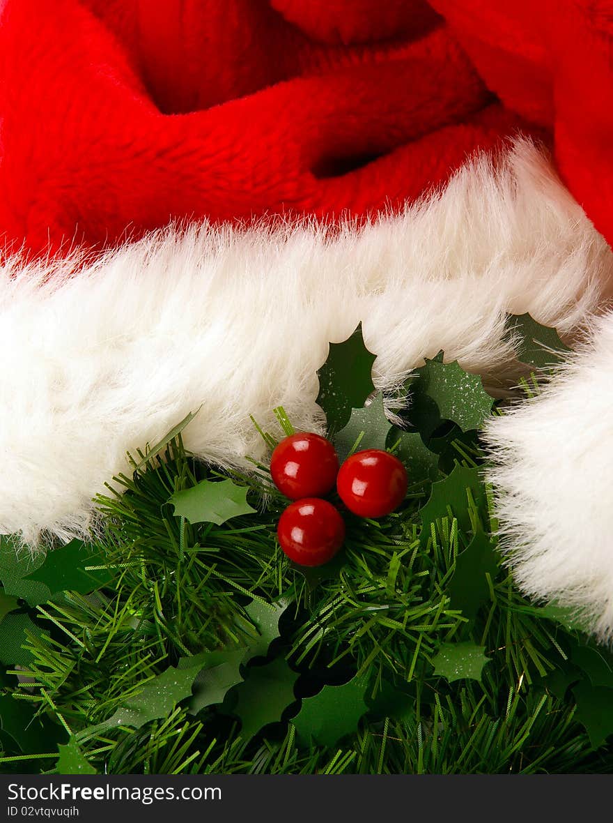 A close up of mistletoe with red berries and a christmas hat