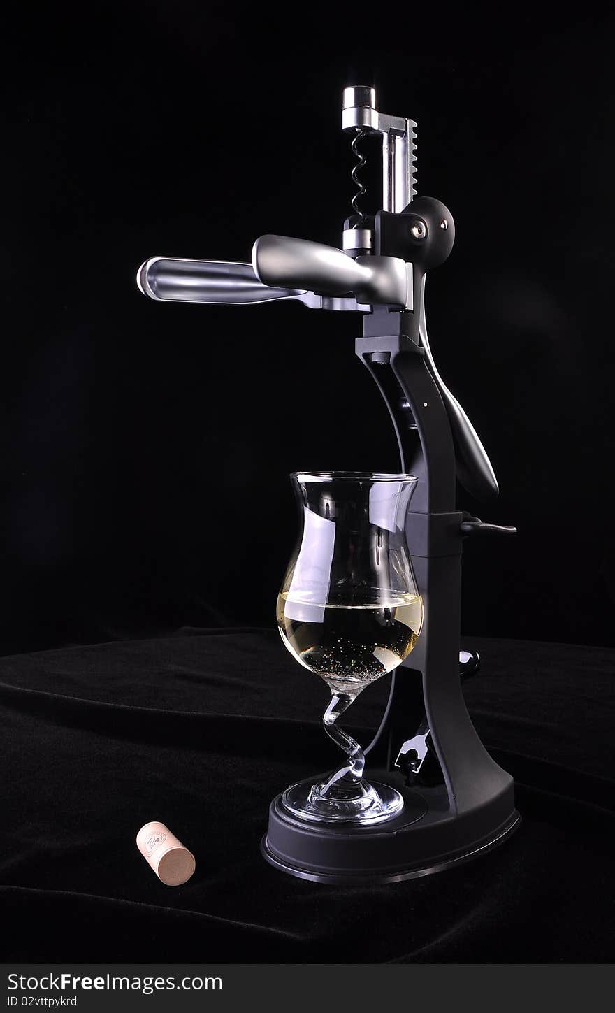 Modern Wine opener made from hard plastic and metal, with a glass of white wine and a cork, on a black background