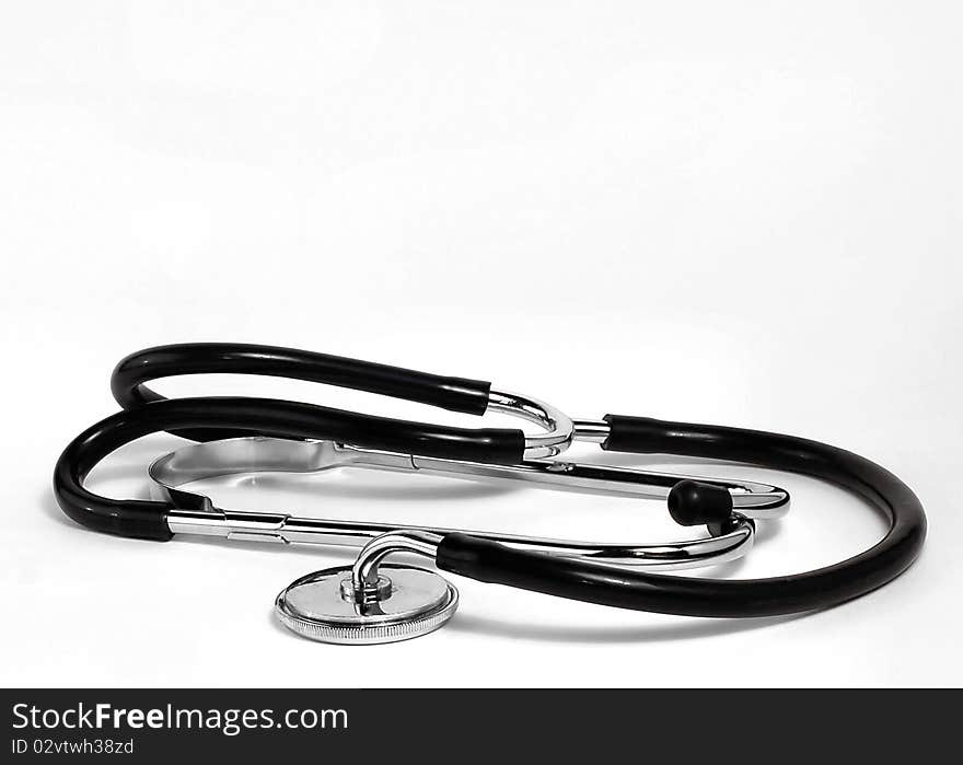 A doctors stethoscope rests on a white background. A doctors stethoscope rests on a white background