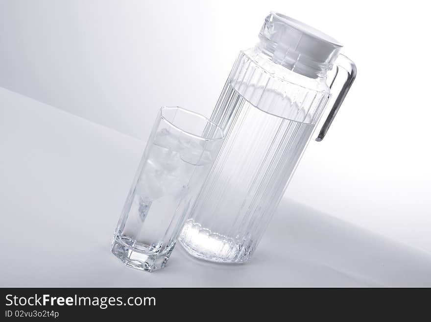 Series. Pitcher and glass with ice cubes of mineral water