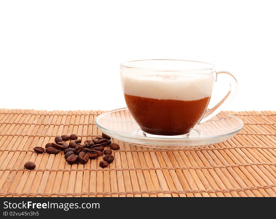 Cup of coffee and beans on bamboo mat