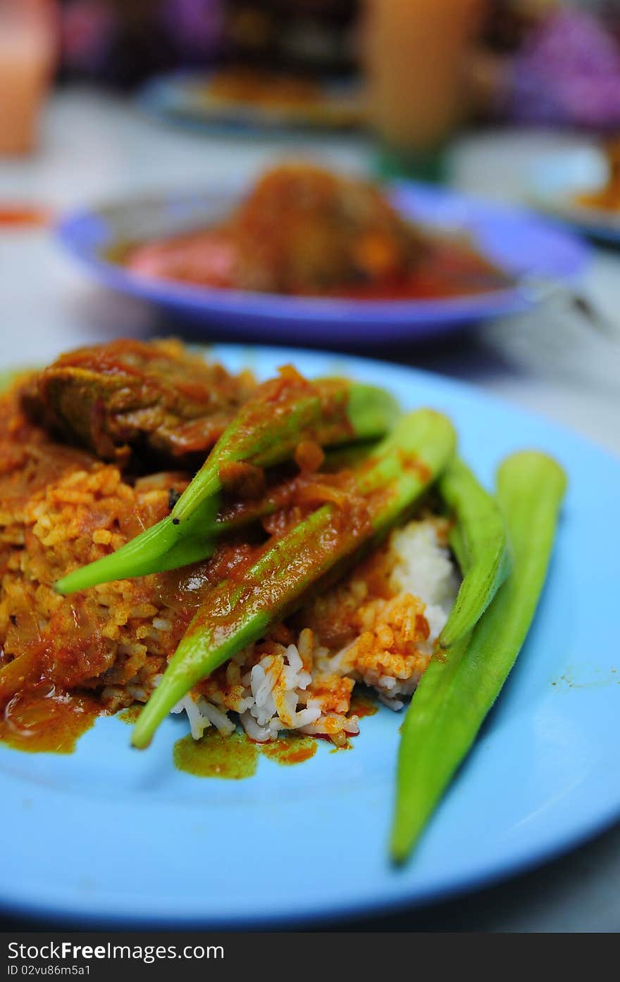 White rice served with beef curry and lady fingers. White rice served with beef curry and lady fingers