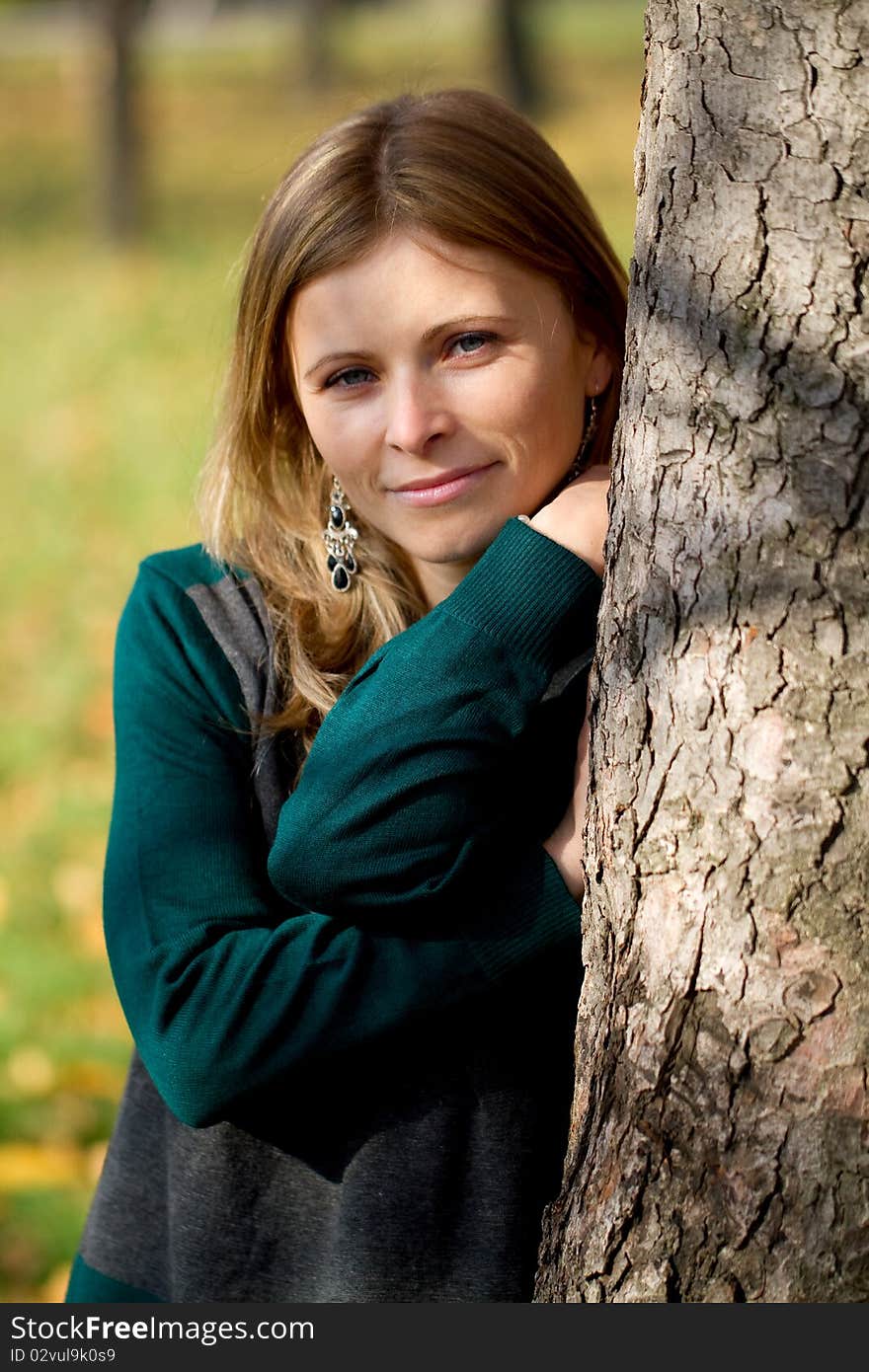 Woman relaxing near a tree in warm autumn light. Woman relaxing near a tree in warm autumn light