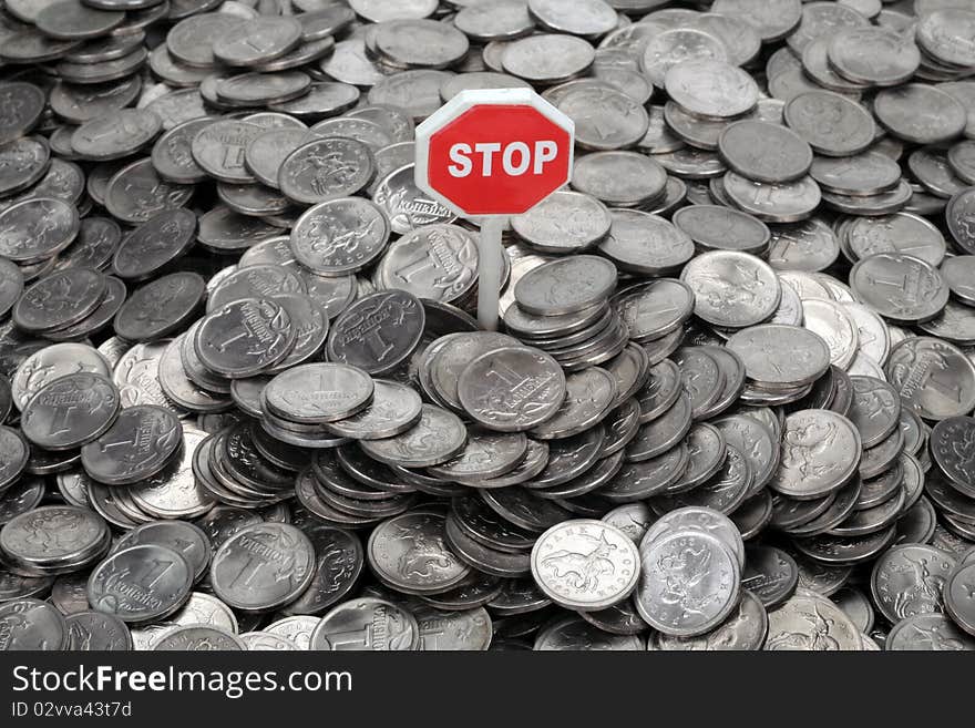 Heap of coins and sign Stop