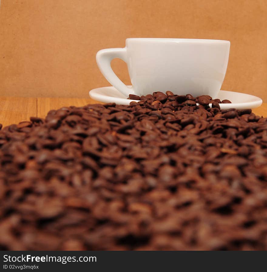 Roasted coffee beans with a white cup. Roasted coffee beans with a white cup