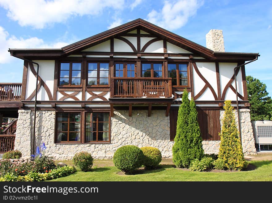 Cottage and small garden on a blue sky background. Cottage and small garden on a blue sky background