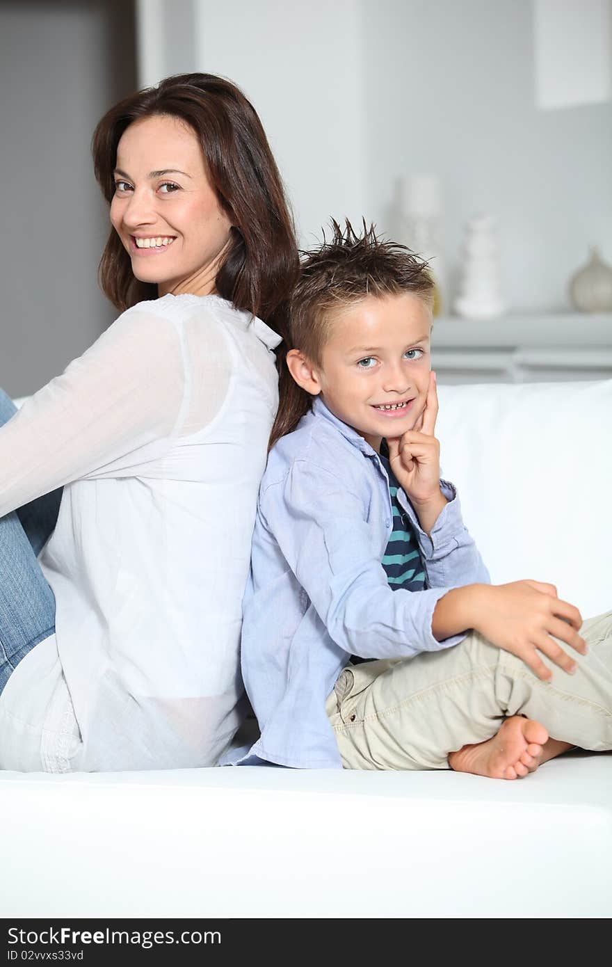 Little blond boy sitting on sofa with mom. Little blond boy sitting on sofa with mom