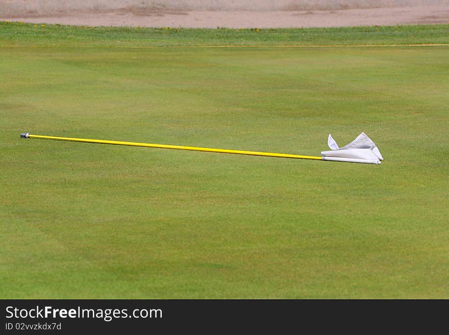 White putting greens flag lying on the green