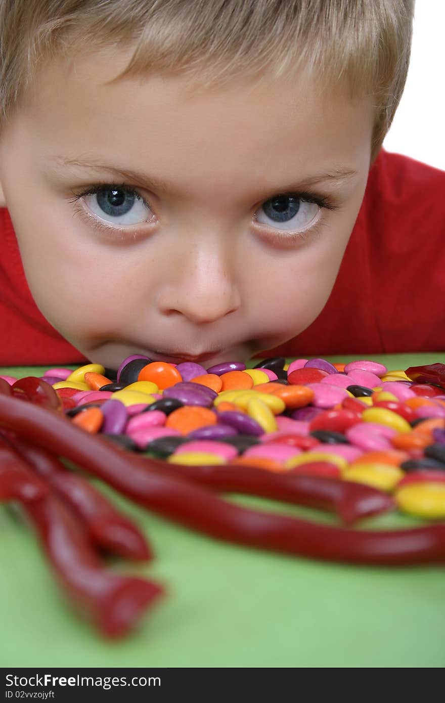 Young blond boy in front of a table filled with sweets