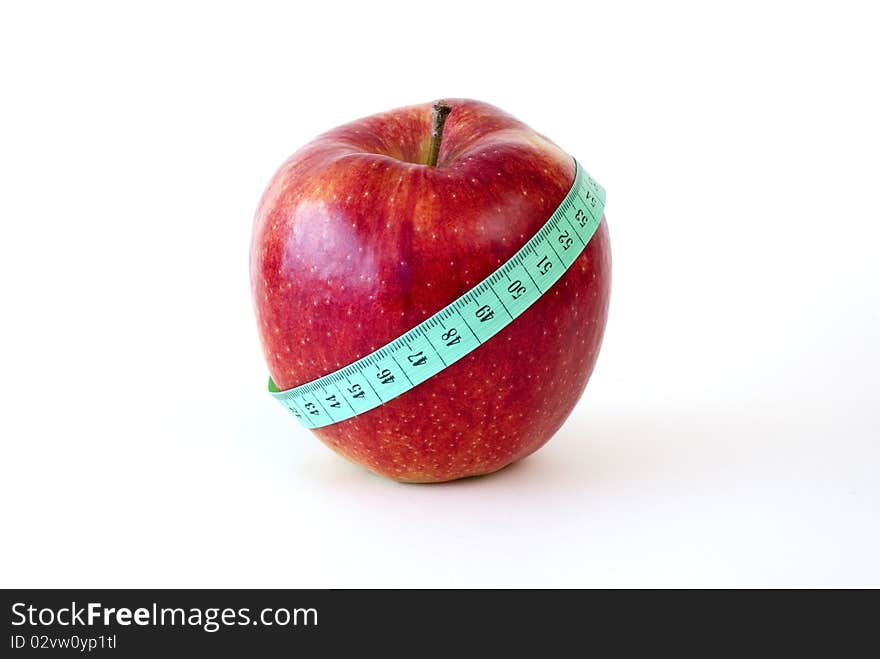 Fresh red apple wrapped up with the tape measure on the white background