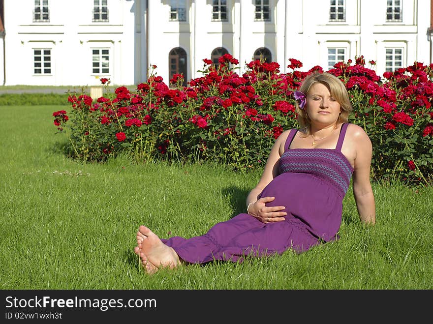 Pregnant woman in the garden in front of the palace