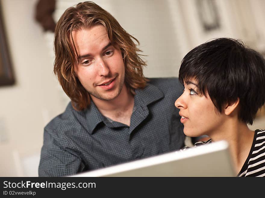 Happy Young Man and Woman Using Laptop Together