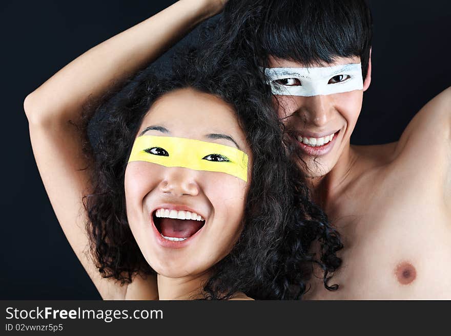 Shot of artistic young people with painted eyes posing together. Shot of artistic young people with painted eyes posing together.