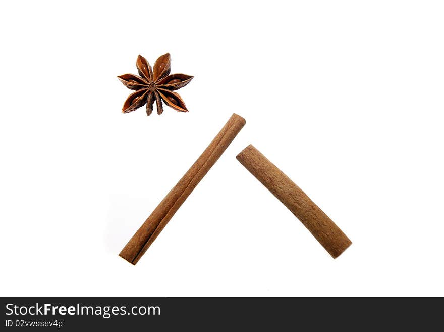 Anise stars and cinnamon sticks isolated on white arranged as a house and star. Christmas (Bethlehem) symbol