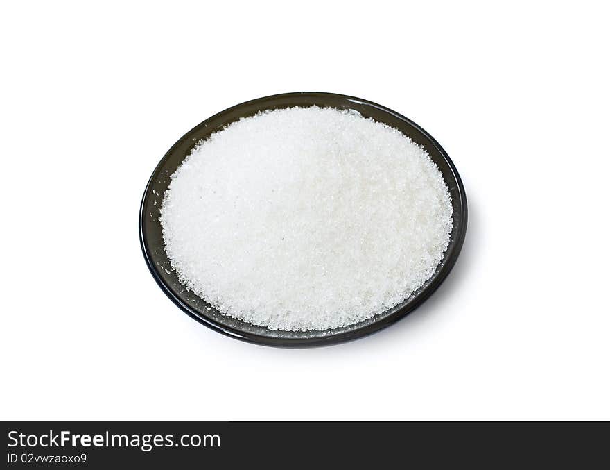 Black plate with white sugar isolated on white background