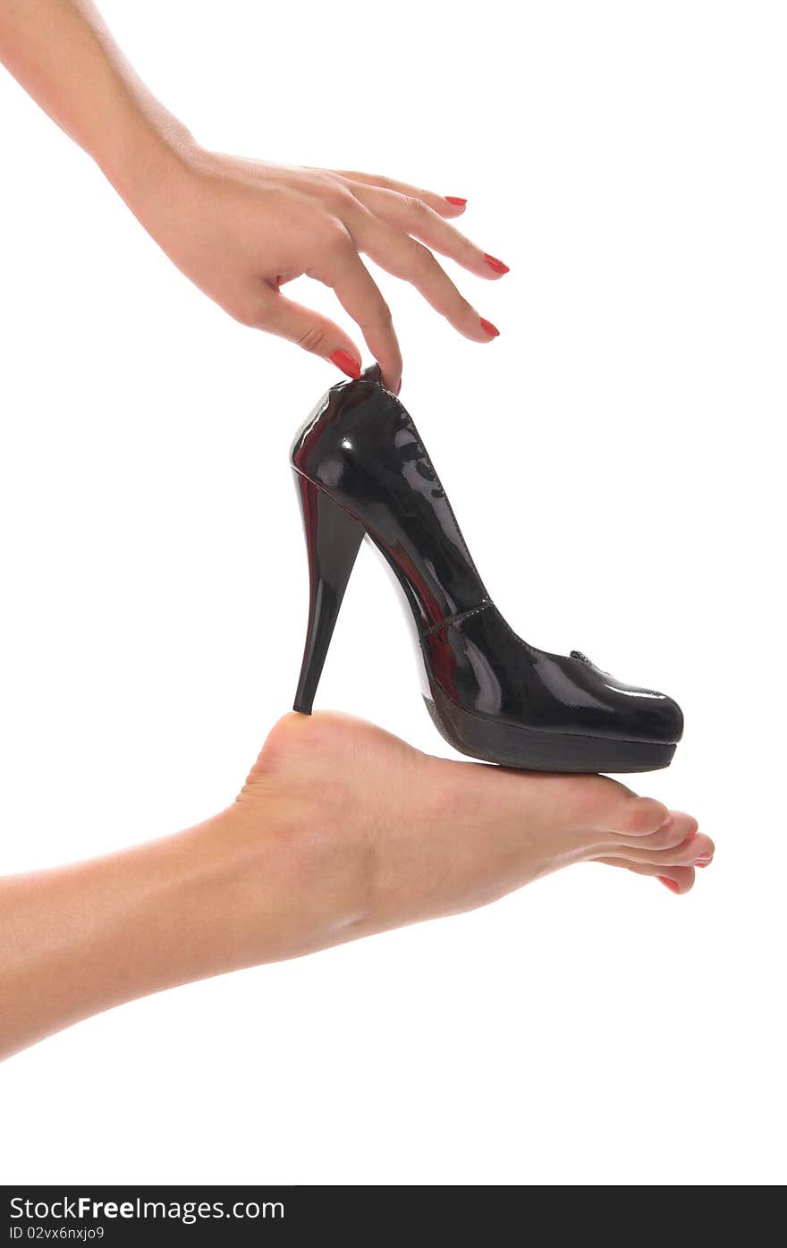 Female hand gracefully tries shoe isolated in white