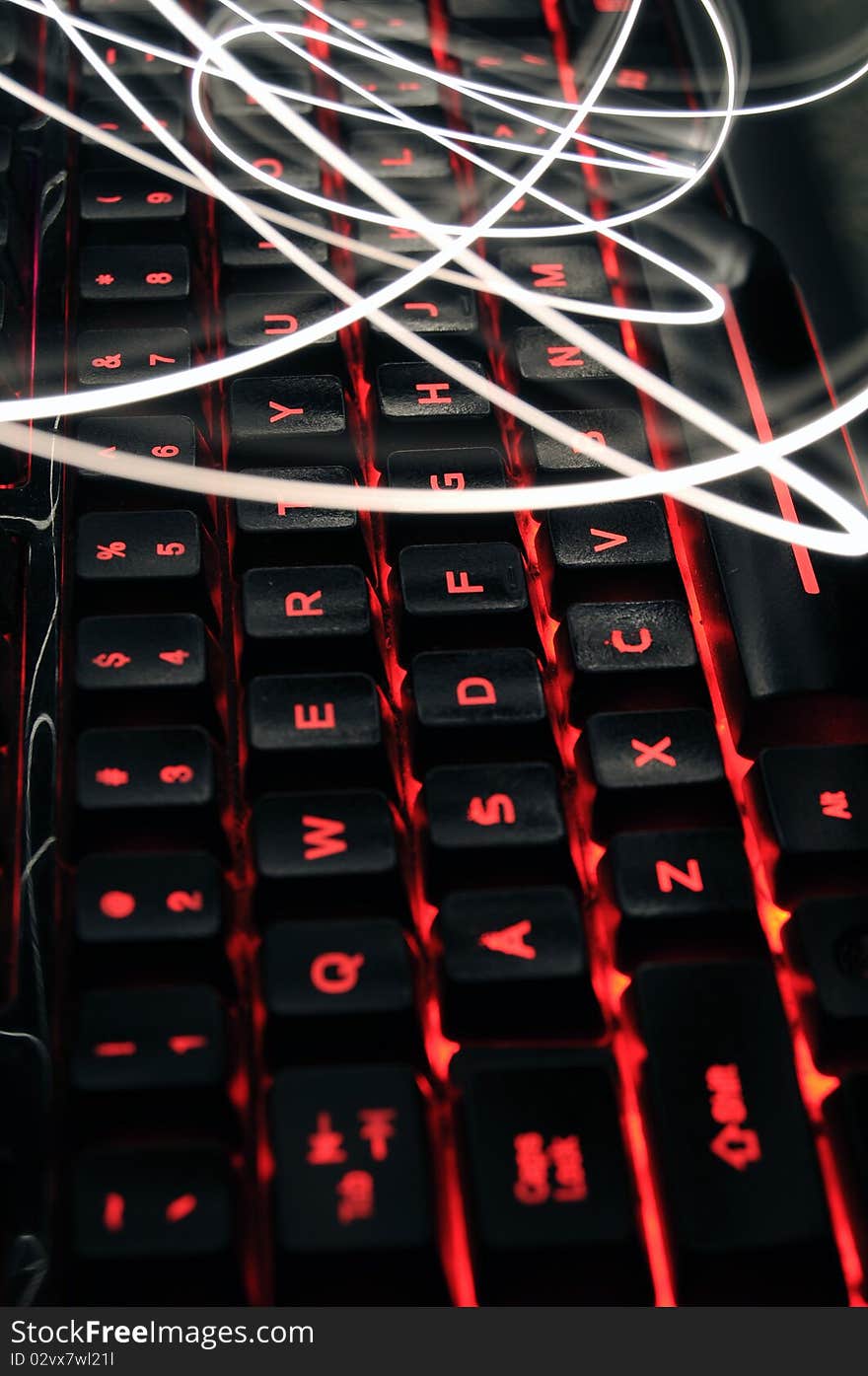 Back lit illuminated keyboard with light painting streaks of light above. Back lit illuminated keyboard with light painting streaks of light above