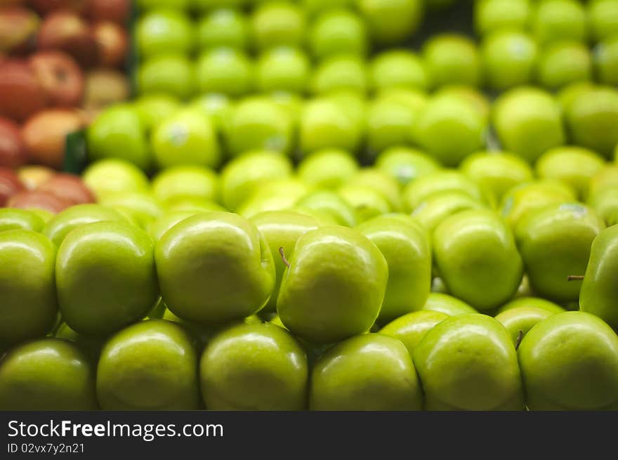 A bunch of green apples piled up at the supermarket.