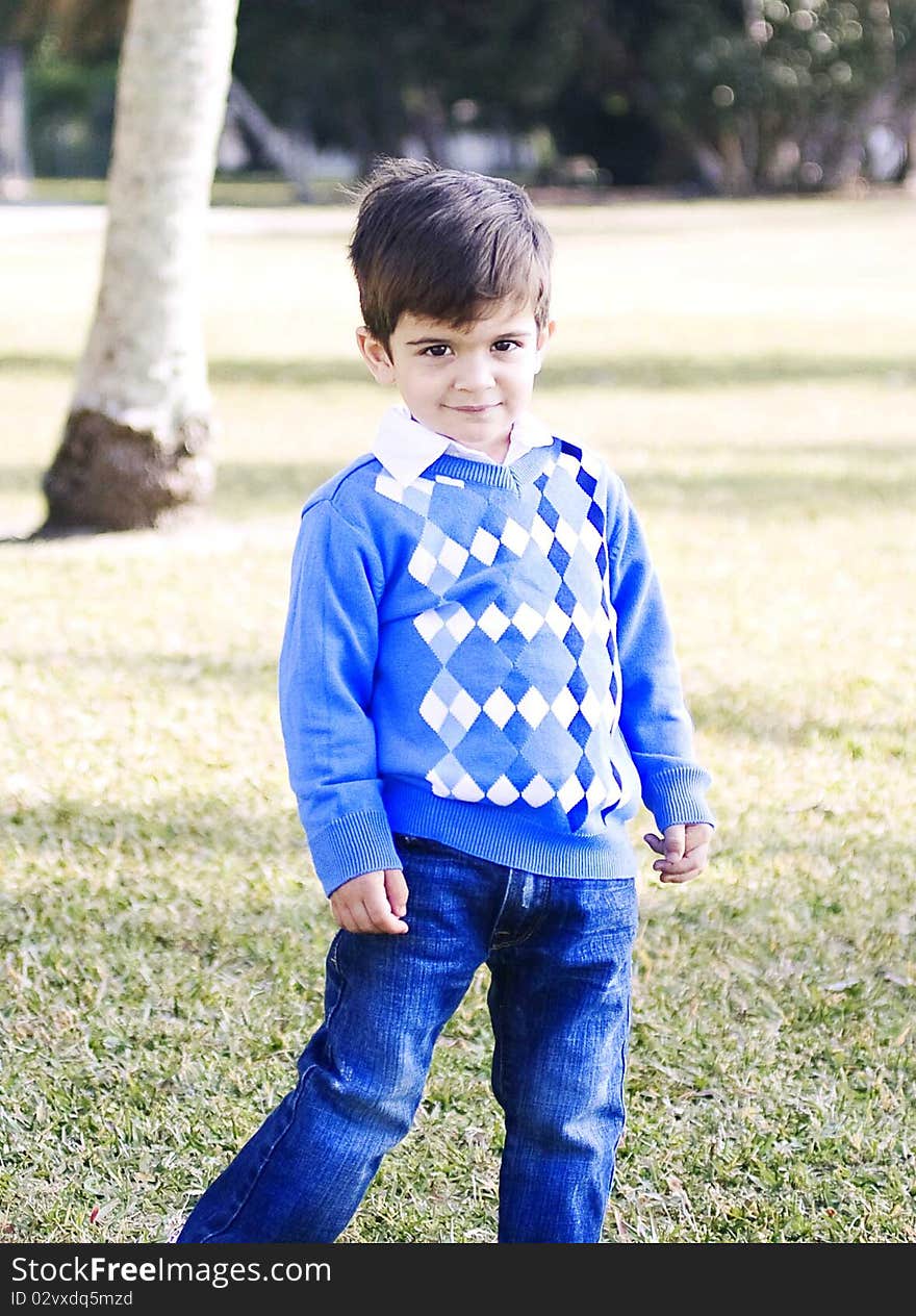 Happy hispanic boy at the park posing for a picture on a bright sunny day.