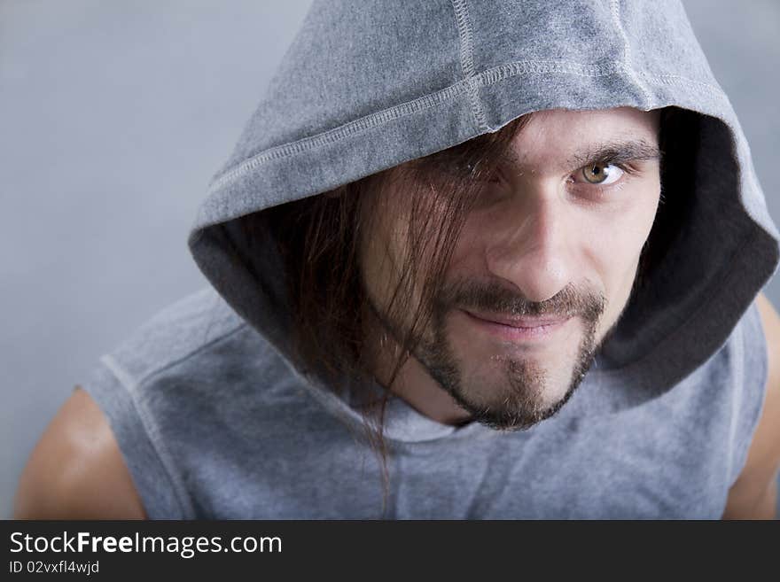 Young man in hool look in camera