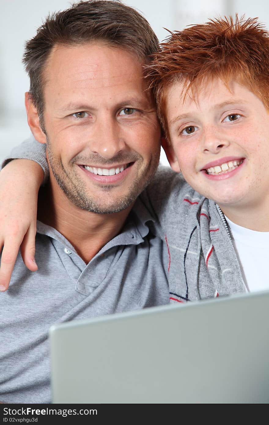 Man and child at home with laptop computer. Man and child at home with laptop computer