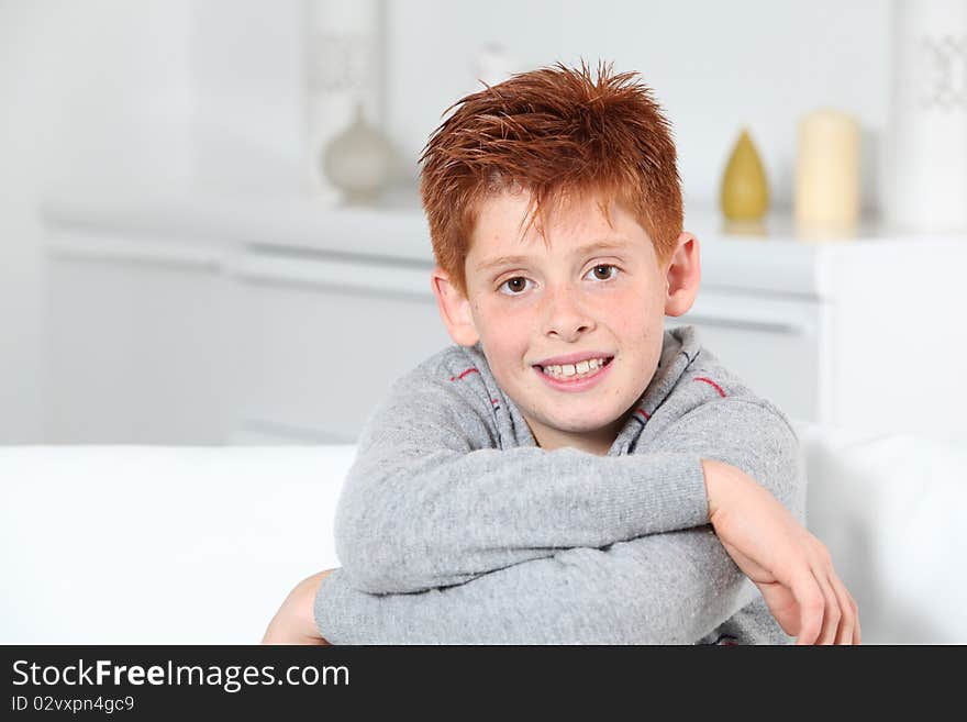 Young boy sitting in sofa with arms crossed. Young boy sitting in sofa with arms crossed