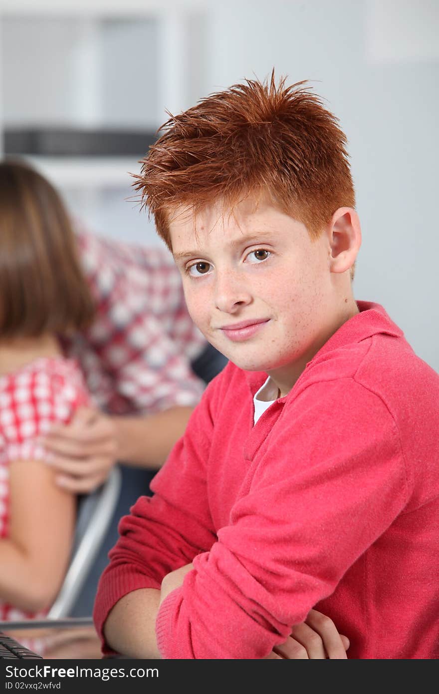 Young red-haired boy in classroom. Young red-haired boy in classroom