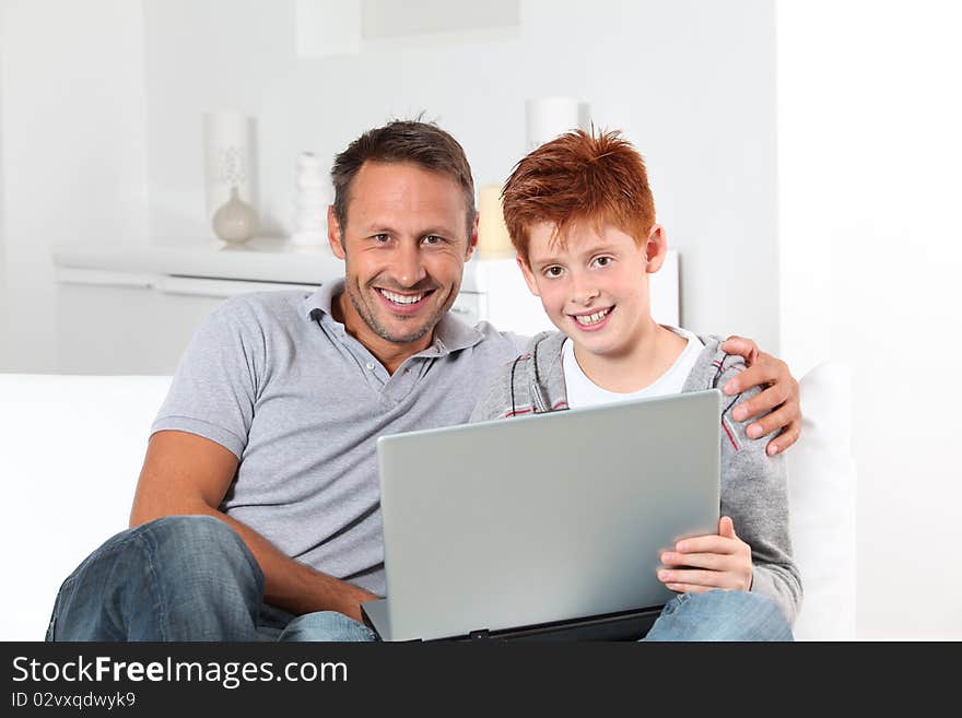 Man and child at home with laptop computer. Man and child at home with laptop computer