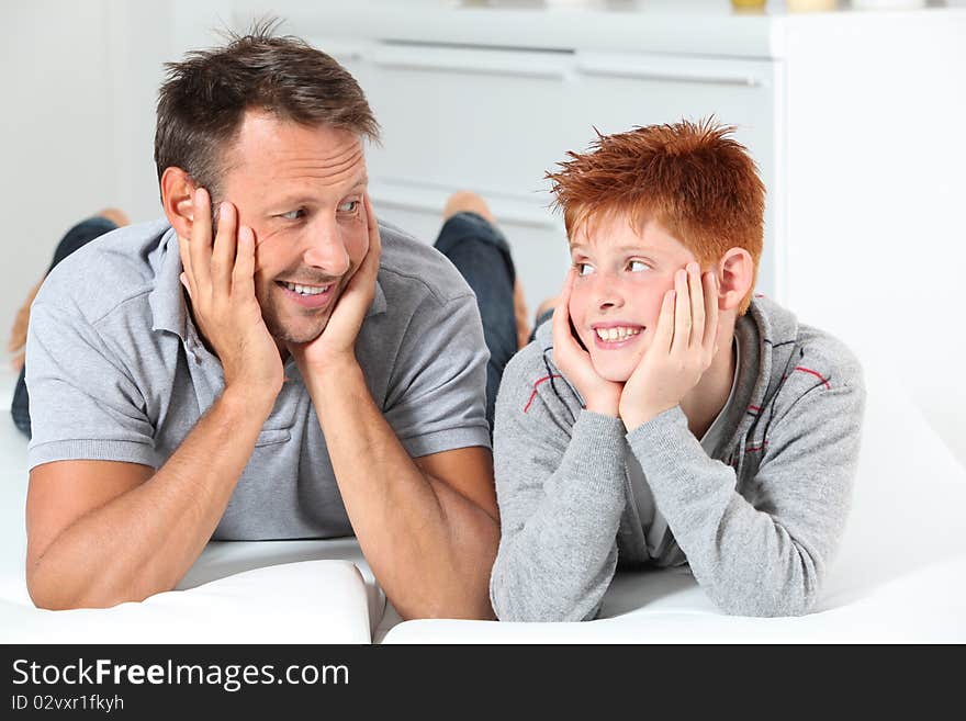 Man with child lying on a sofa at home. Man with child lying on a sofa at home