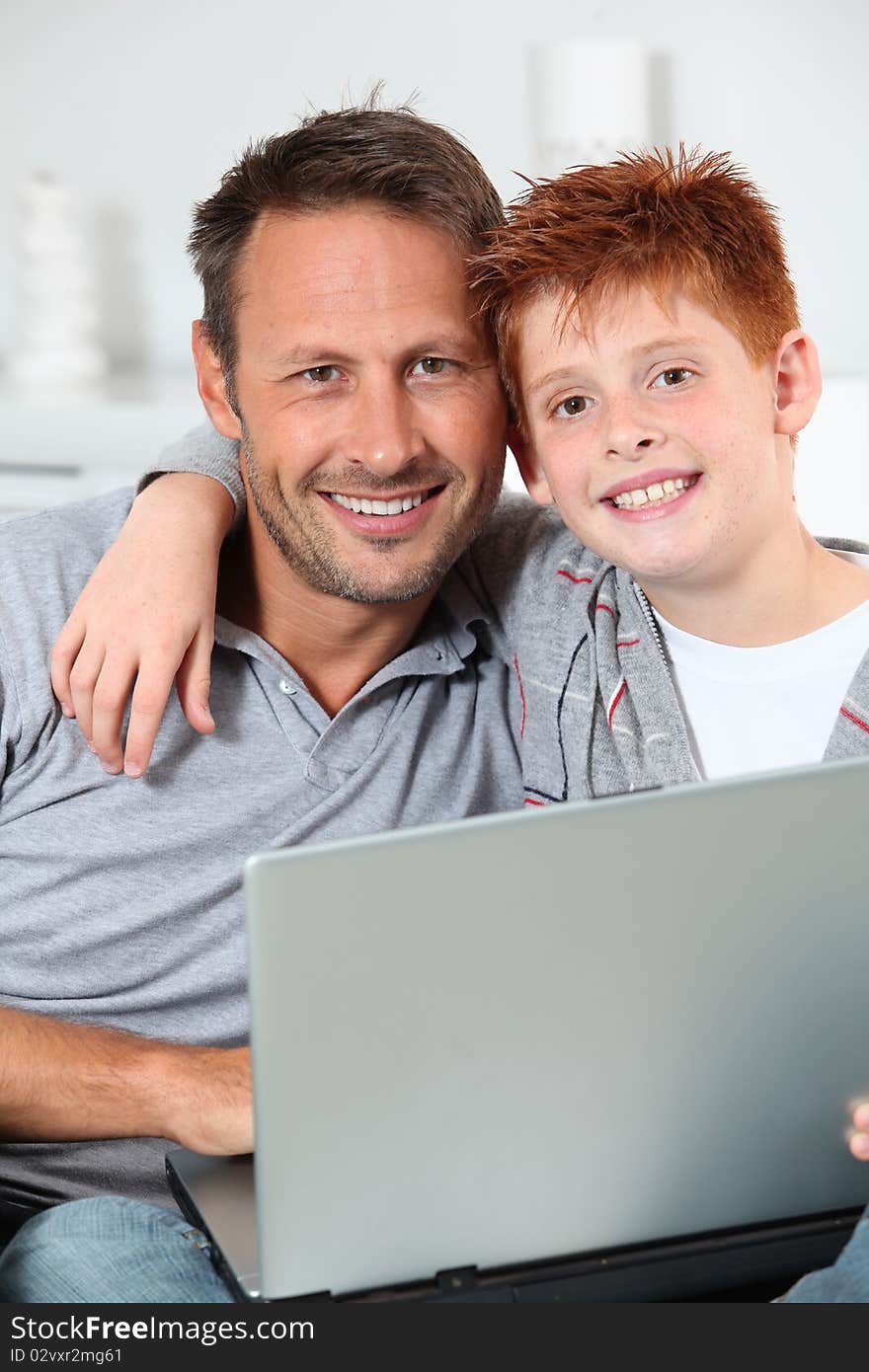 Man and child at home with laptop computer. Man and child at home with laptop computer