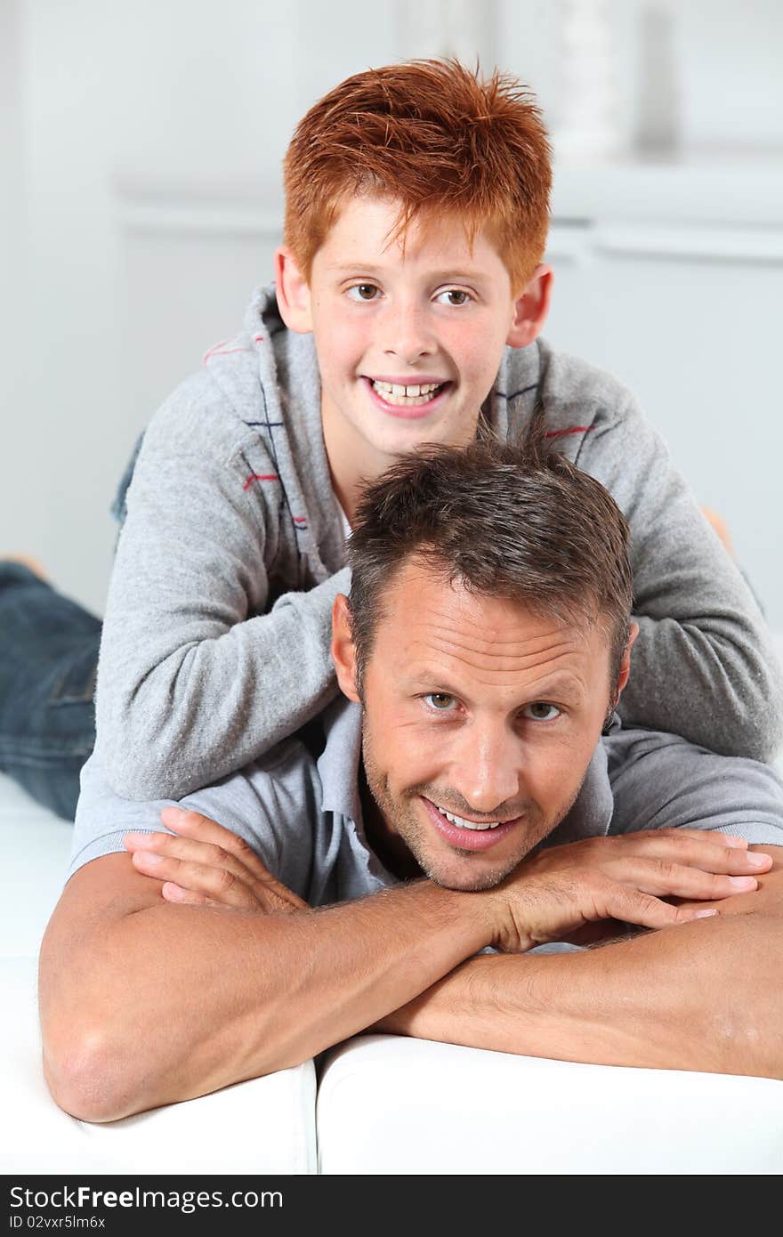 Man with child lying on a sofa at home. Man with child lying on a sofa at home