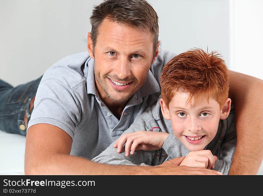 Man with child lying on a sofa at home. Man with child lying on a sofa at home