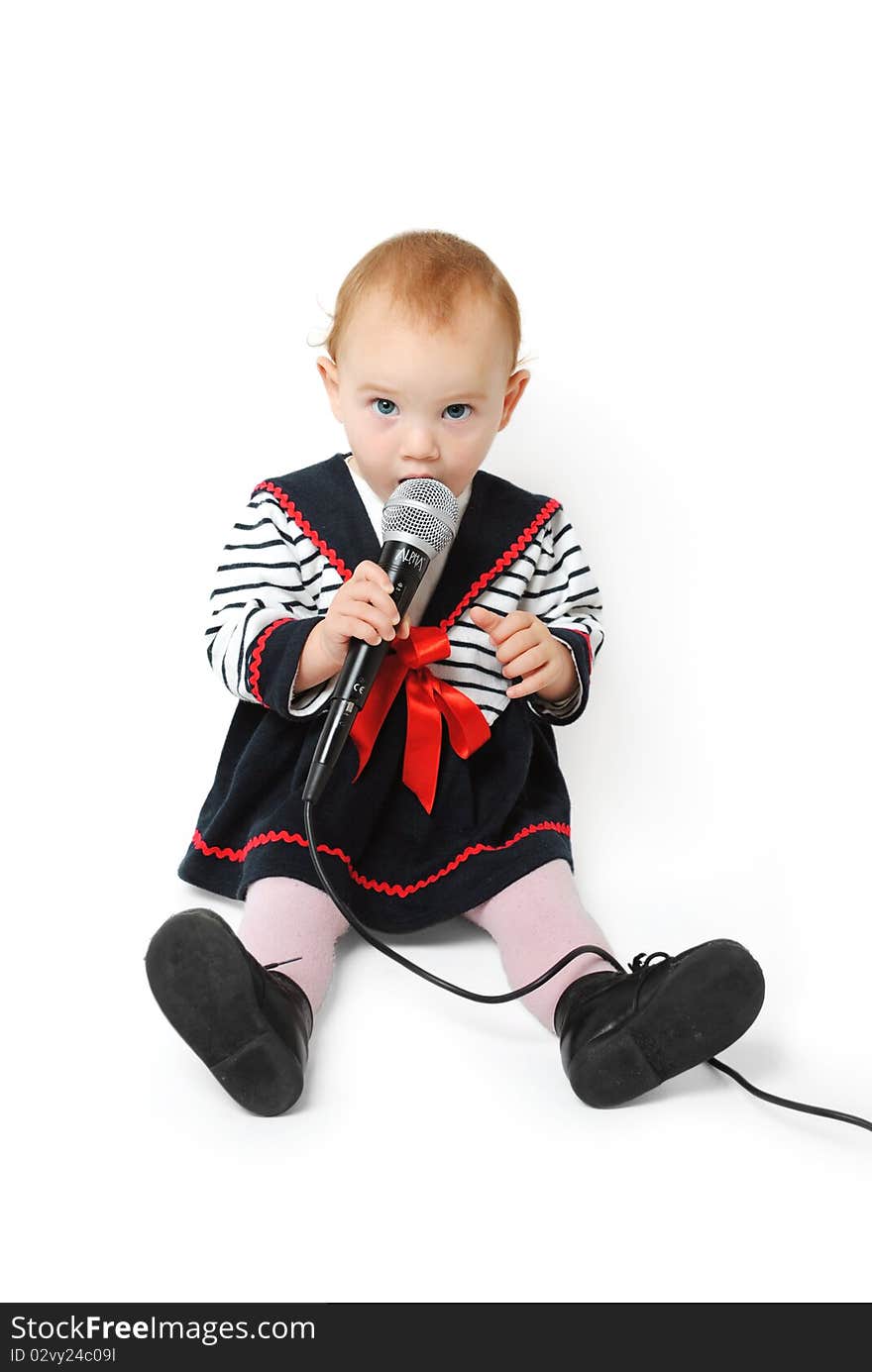 Sweet one year old baby girl with blue eyes singing with a microphone in her hand isolated on a white background. Sweet one year old baby girl with blue eyes singing with a microphone in her hand isolated on a white background