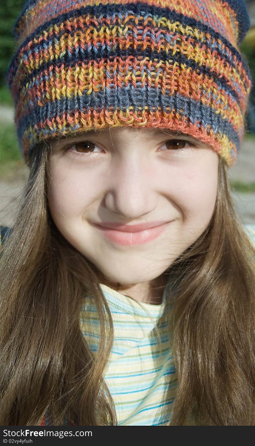 Cute smiling girl in colored knitted hat