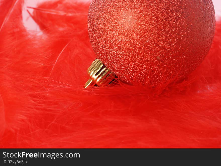 Red christmas bulb on red fluffy feathers