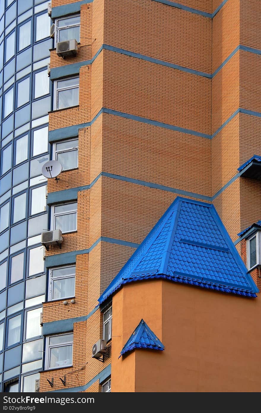 Facade of new, just populated brick house with blue roof. Facade of new, just populated brick house with blue roof