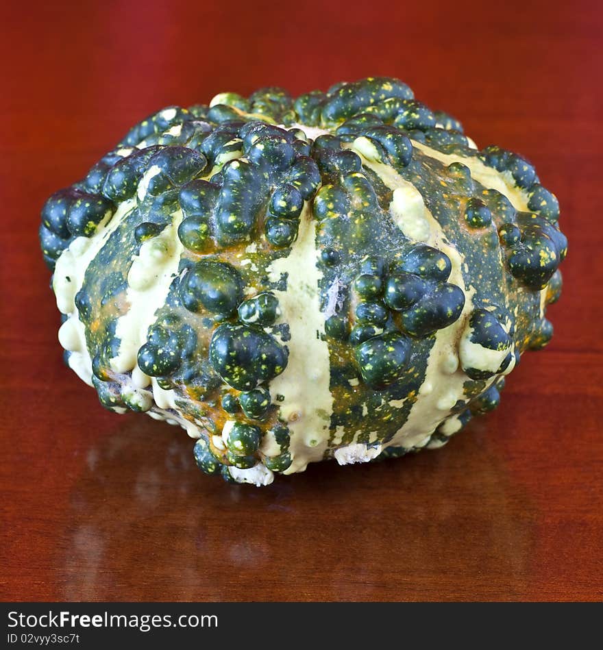 East a pumpkin on a table of dark wood. East a pumpkin on a table of dark wood