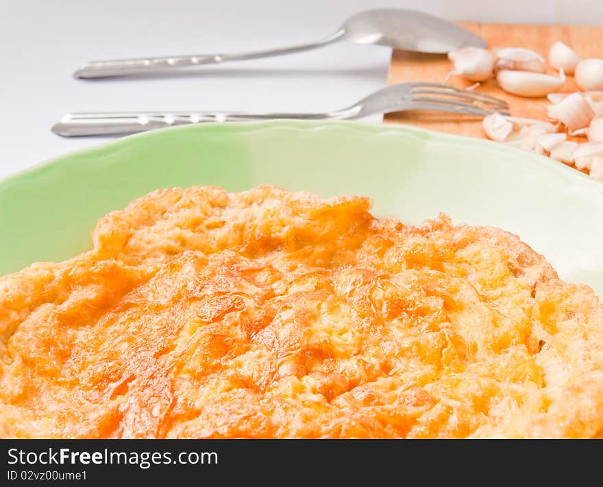 Omelet in a green dish on white background.