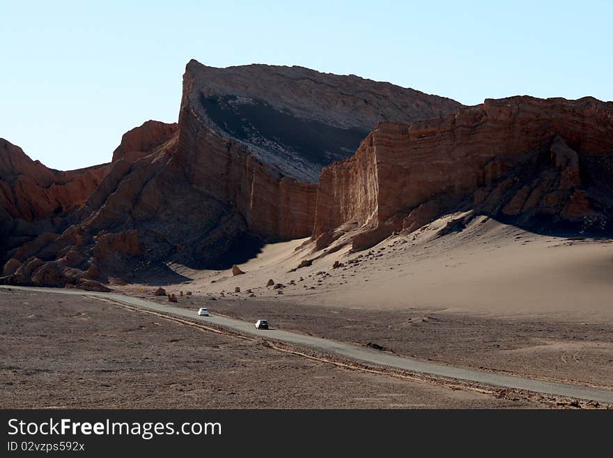 Rocky formation at Atacama Desert, in Chile, a region called Valle de la Luna (Moon Valley), with cars passing by. Rocky formation at Atacama Desert, in Chile, a region called Valle de la Luna (Moon Valley), with cars passing by.