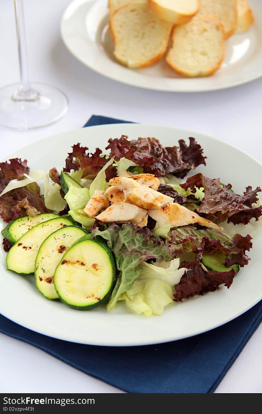 Salad with vegetables and chicken on a white plate