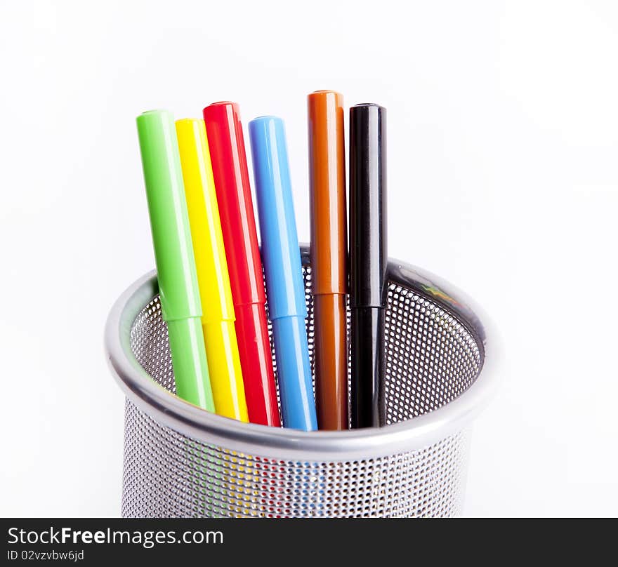 Black metal pencil cup filled with colorful pencils.