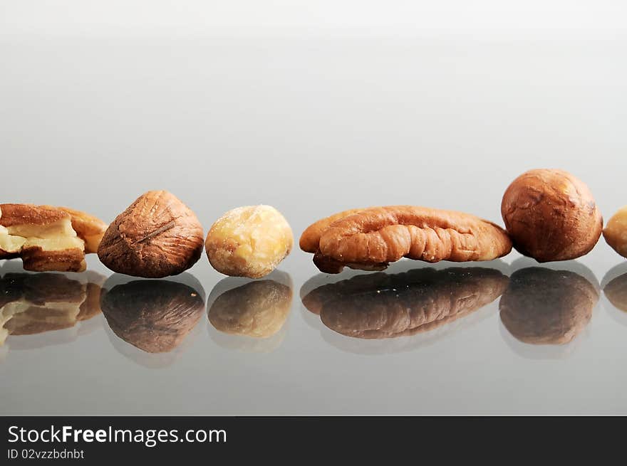 Macro closeup of a pile an arrangement of raw nuts. These are hazelnuts, chestnuts, filberts, peanuts, and pecans. Macro closeup of a pile an arrangement of raw nuts. These are hazelnuts, chestnuts, filberts, peanuts, and pecans.