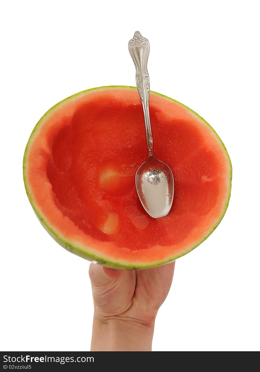 Hand holding a cut watermelon with a spoon. This melon has been eaten. Hand holding a cut watermelon with a spoon. This melon has been eaten