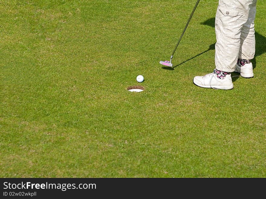 Golf ball on lip of cup of lovely beautiful golf course