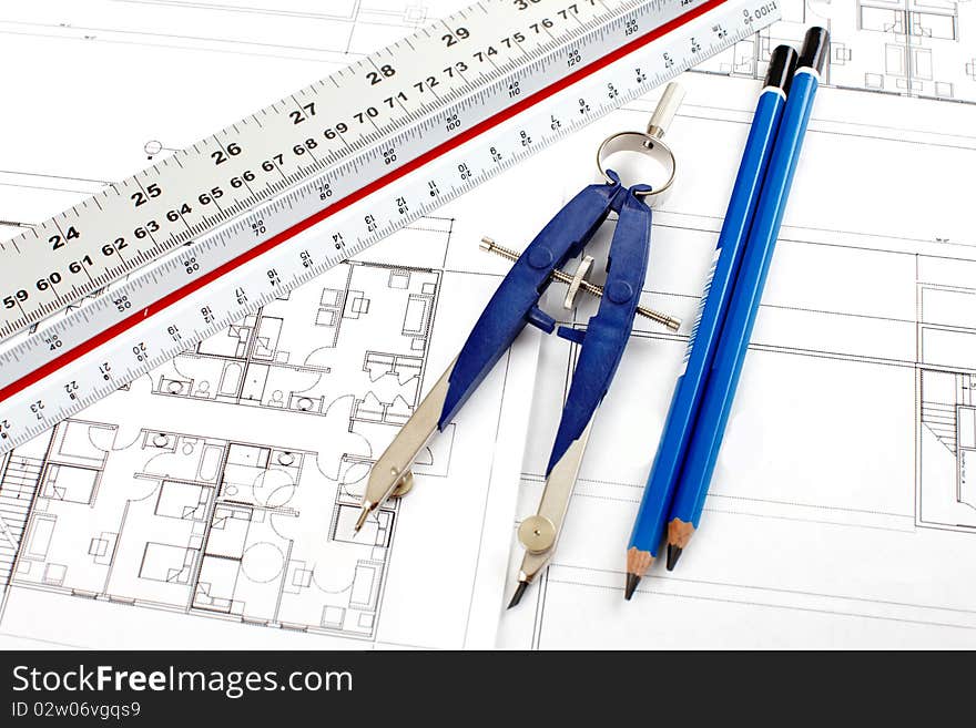 Pencil and compass over a construction drawing. Pencil and compass over a construction drawing