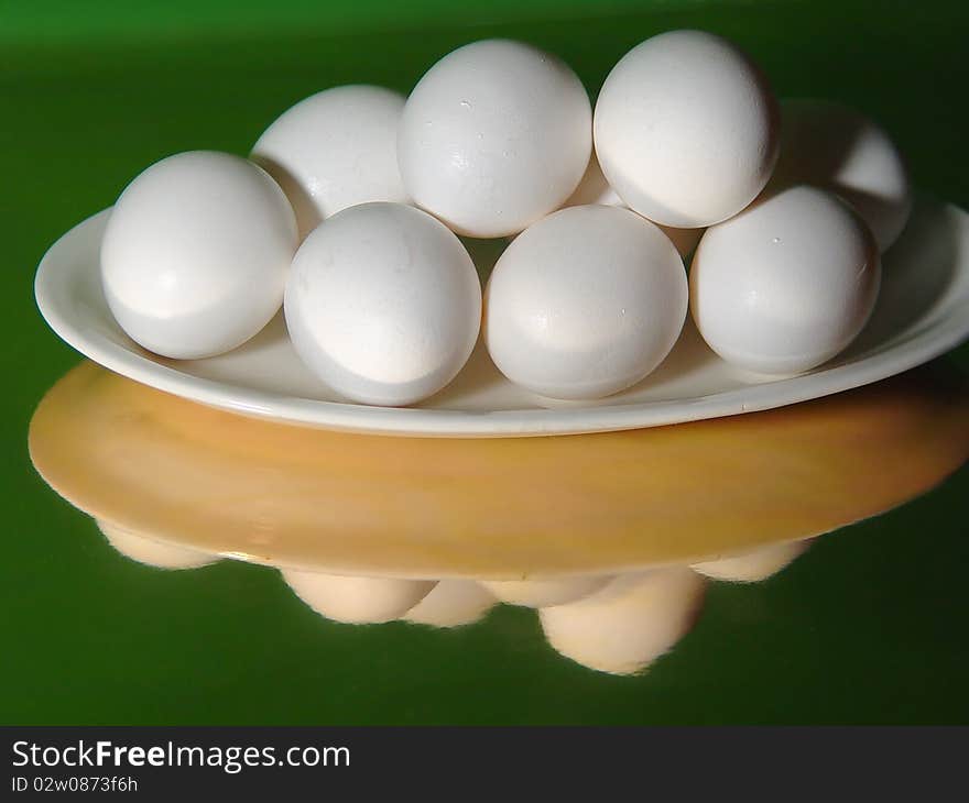 Dish of eggs on a white platter on a reflective base